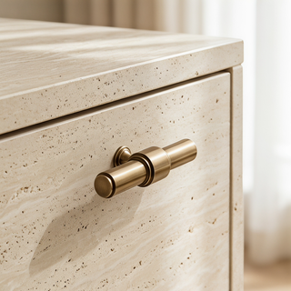 Satin Brass Kensington T-bar knob installed on a cream stone cabinet drawer